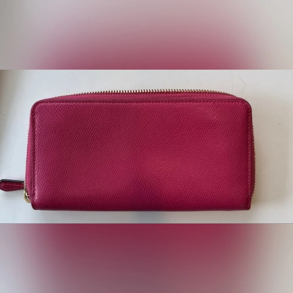 Coach Pink Leather Wallet with Gold Logo and Zip Closure.